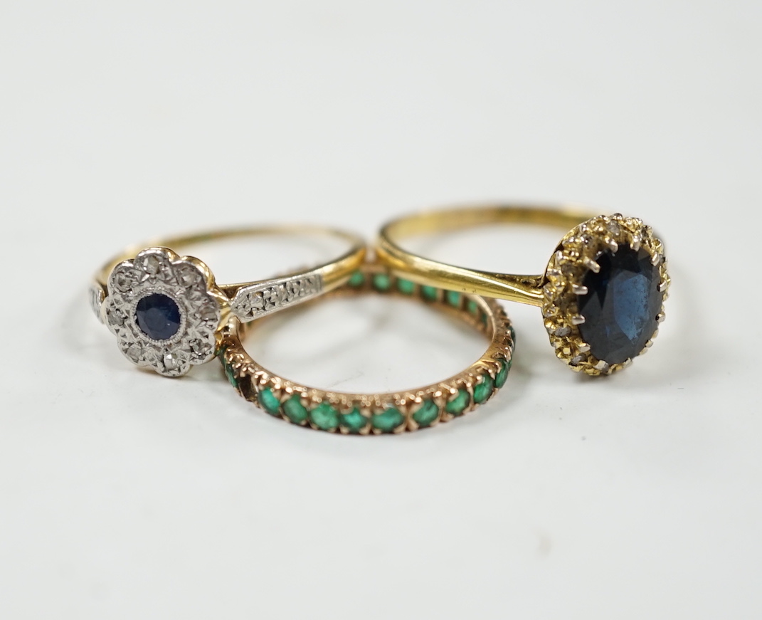 A 1920's 18ct and plat, sapphire and diamond set flower head cluster ring, size L, a 1960's 18ct gold sapphire and diamond set oval cluster ring and a yellow metal and emerald chip set full eternity ring, gross weight 6.